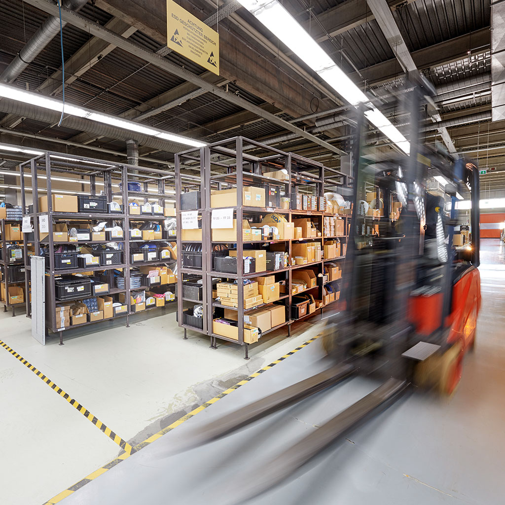Mitarbeiter überwachen Produktionslinie an verschiedenen Prüfterminals in der Fertigungshalle