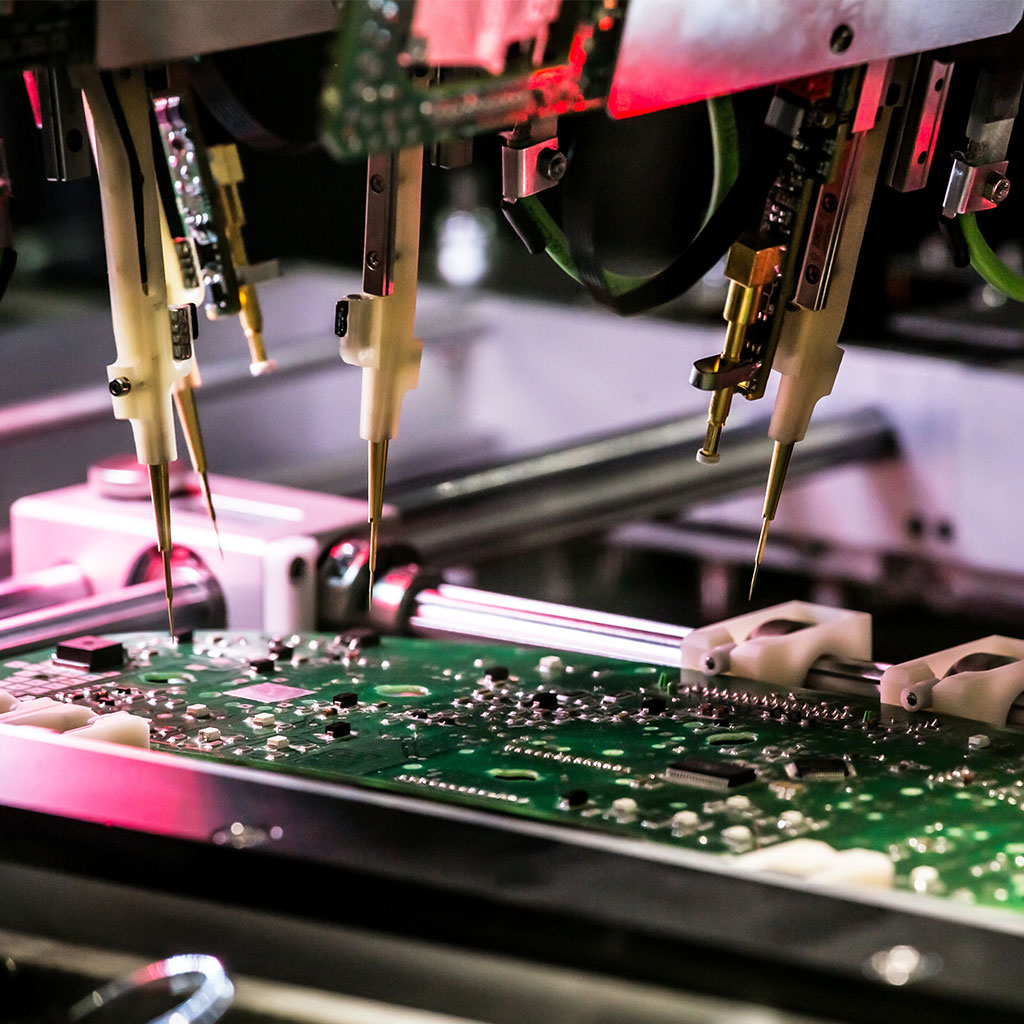 Prüfstation mit mehreren elektronischen Testnadeln auf grüner Leiterplatte