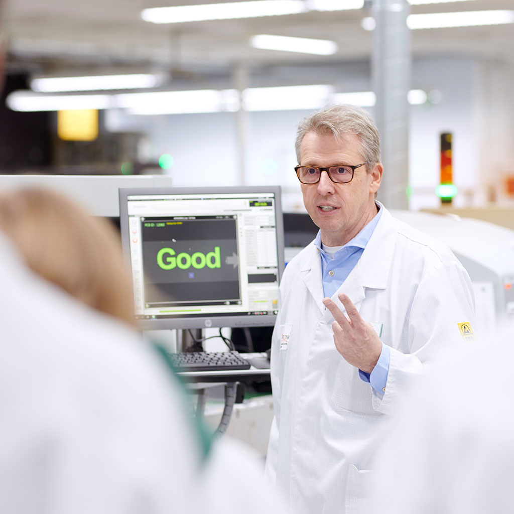 Fachkraft arbeitet an Testsystem für elektronische Baugruppen